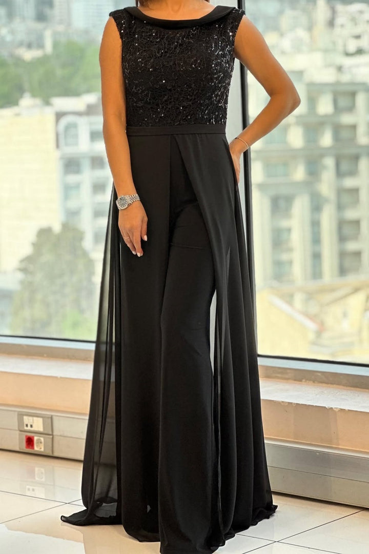 Woman wearing a black crew-neck textured-panel jumpsuit with a streamlined fit, front view