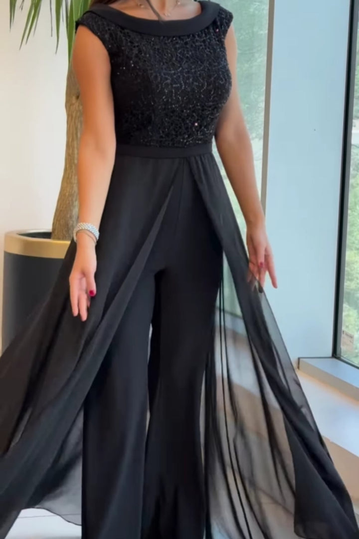 Woman in a black textured jumpsuit styled for a day-to-night look, three-quarter view