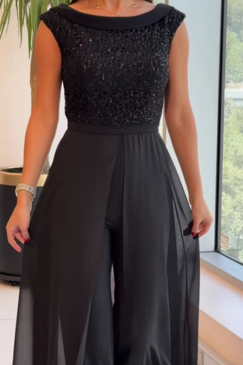 Back view of a woman wearing a sleek black crew-neck jumpsuit with subtle textured panels