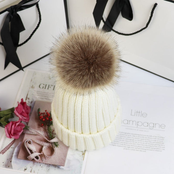 Detail shot of the pom on the Lorette beanie in light gray