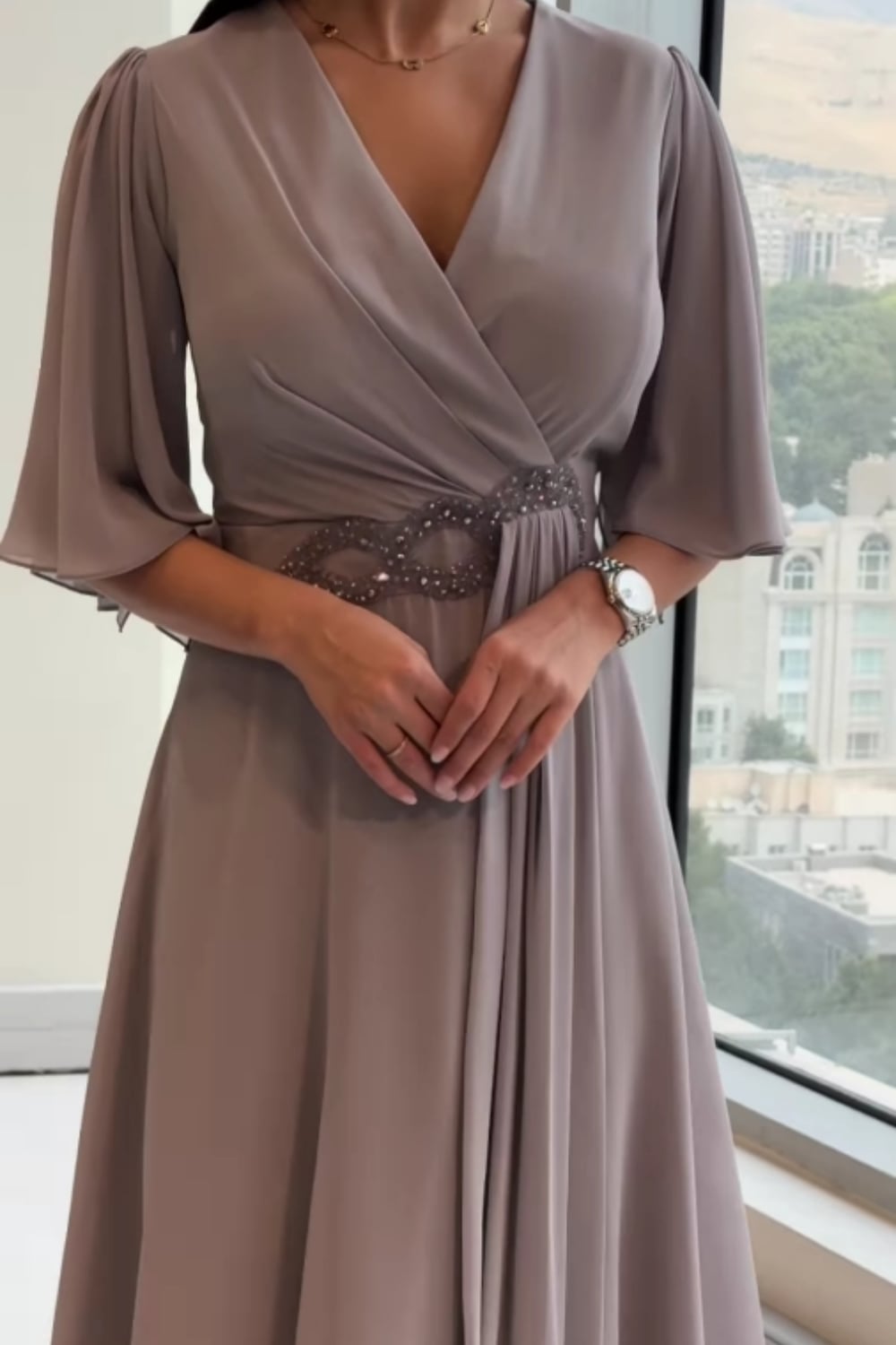 Model in a navy V-neck maxi dress styled for an evening occasion, full-length view
