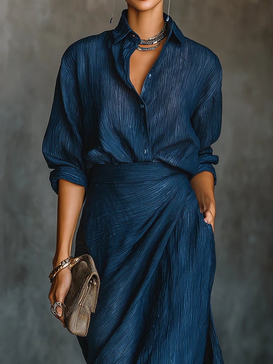 Close-up detail of the dark blue long skirt and matching shirt set showing flowing silhouette