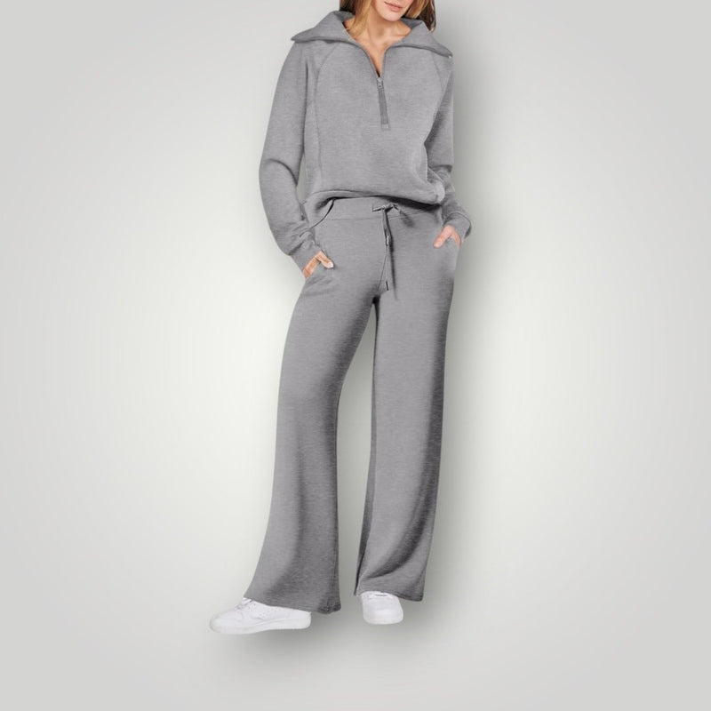 Woman wearing a gray half-zip sweatshirt and matching wide-leg sweatpants loungewear set, front view