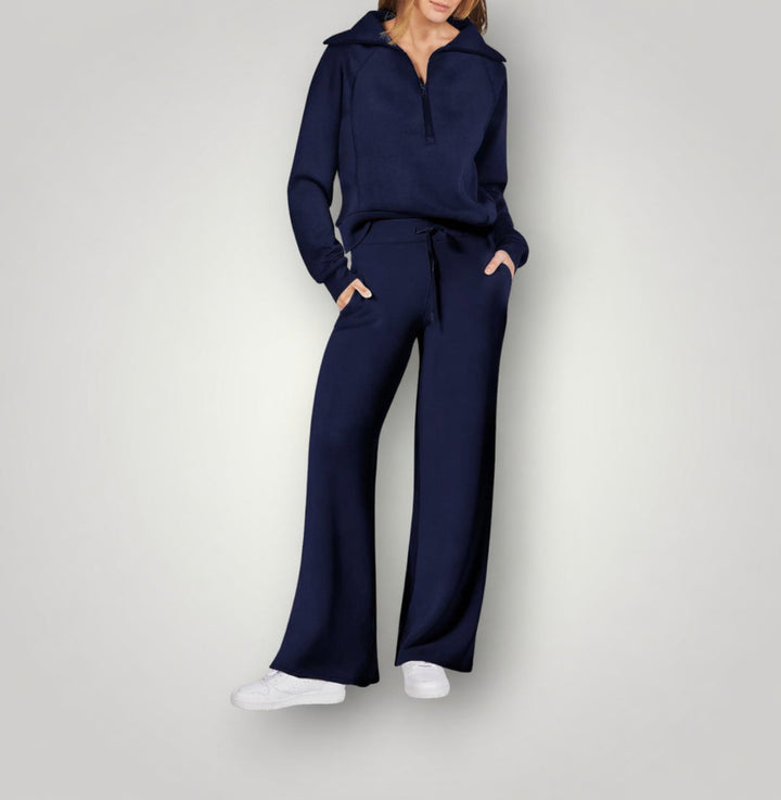 Woman wearing the Luna two-piece loungewear set in dark blue, styled with white sneakers