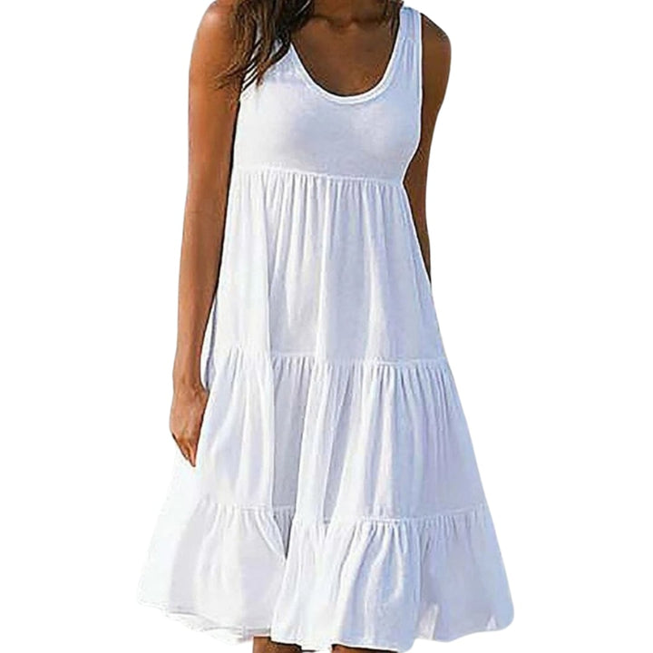 Woman wearing a white sleeveless three-tiered ruffle midi dress with a scoop neckline, standing outdoors in natural light