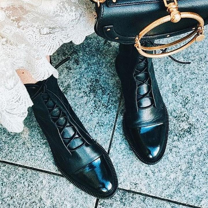 Model wearing Luna heeled boots in black with a midi dress