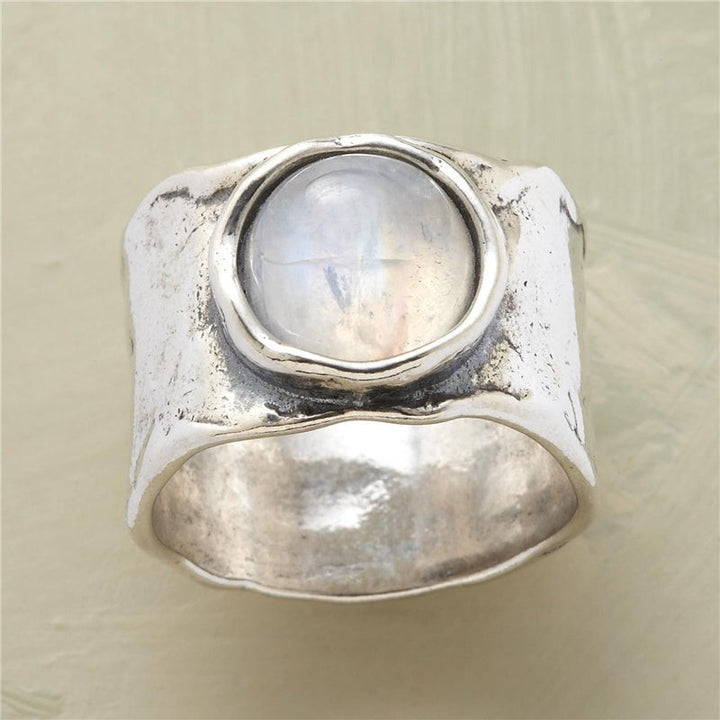 Close-up of a silver moonstone ring with a glowing white and blue-gray center stone