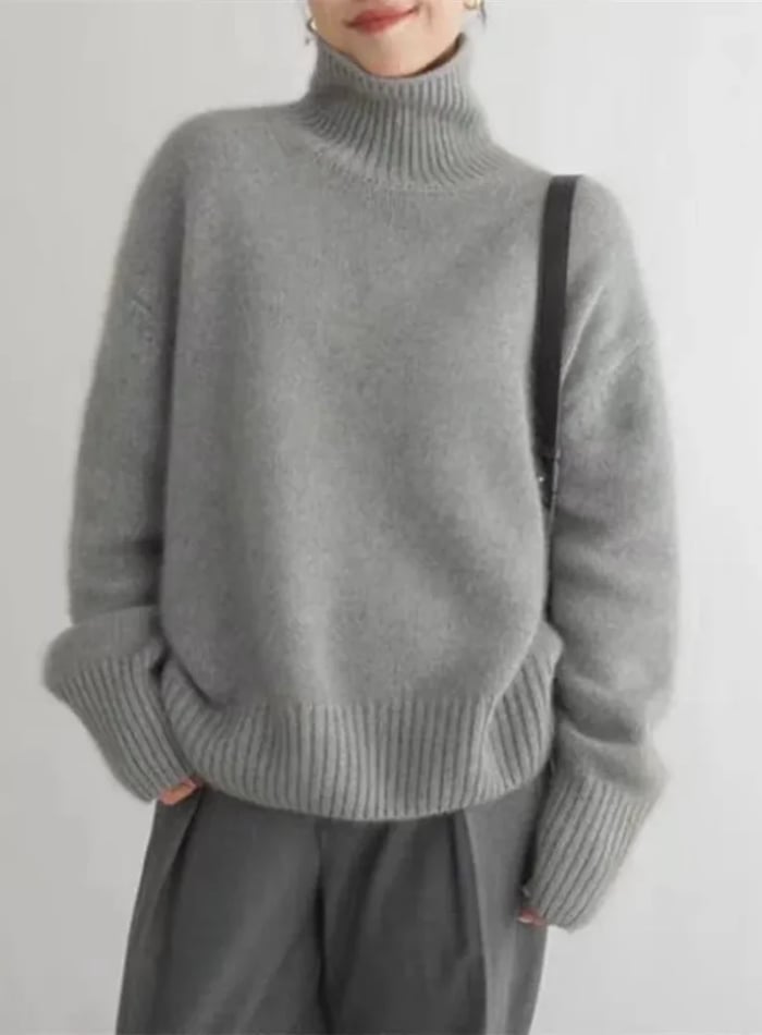 Model wearing the grey turtleneck sweater paired with tailored trousers