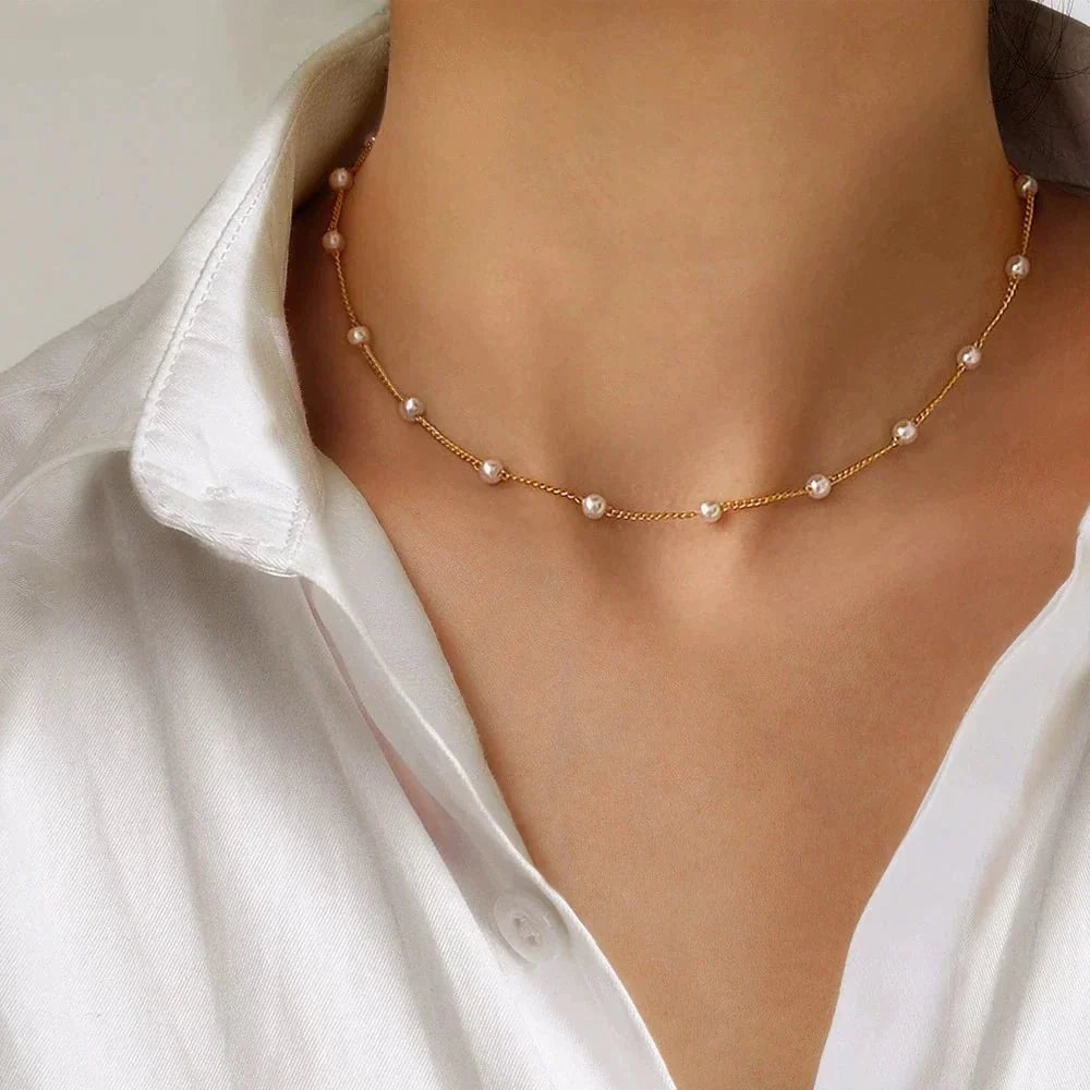 Close-up of a gold pearl necklace with a lustrous finish on a neutral background