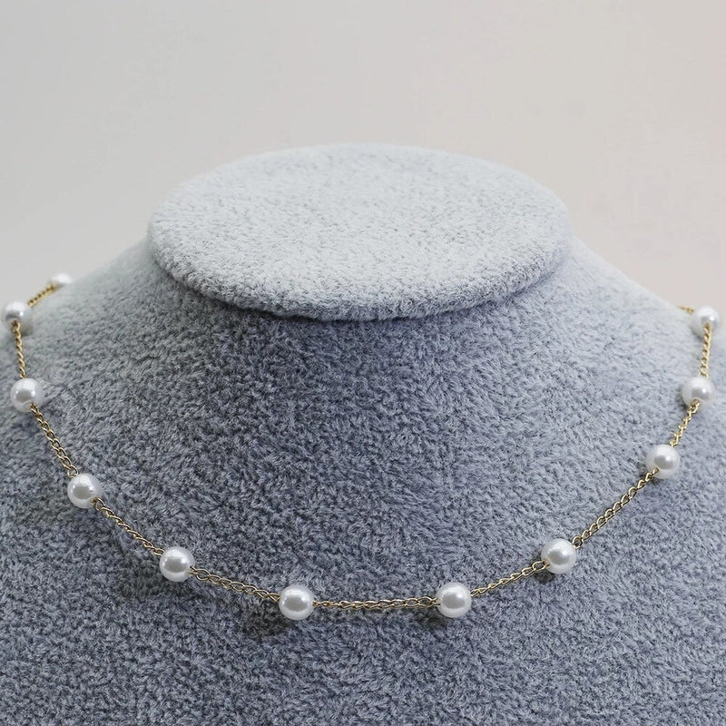 Gold pearl necklace draped elegantly to highlight its lightweight and polished design