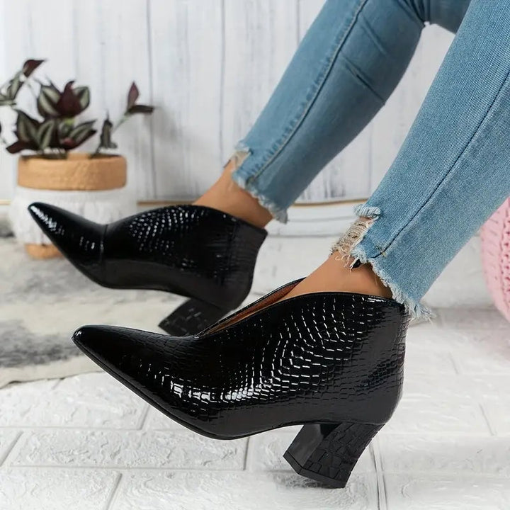 Women's textured ankle boots in black with curved cut and mid block heel, front view