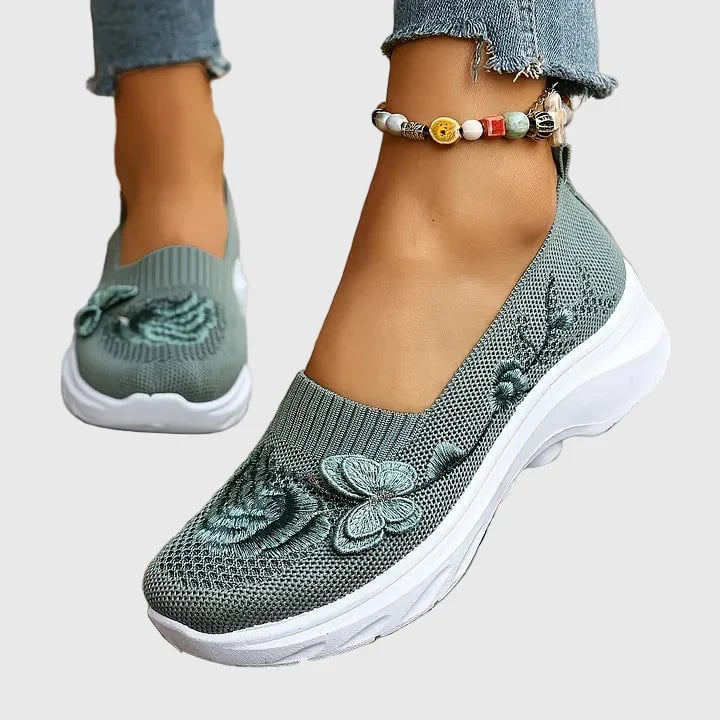 Side view of Lydia slip-on sneakers in green showing butterfly embroidery and lightweight sole