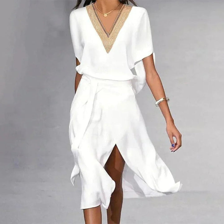 Side view of Florimay Lyra white midi dress showing flowing asymmetric hem and self-tie belted waist