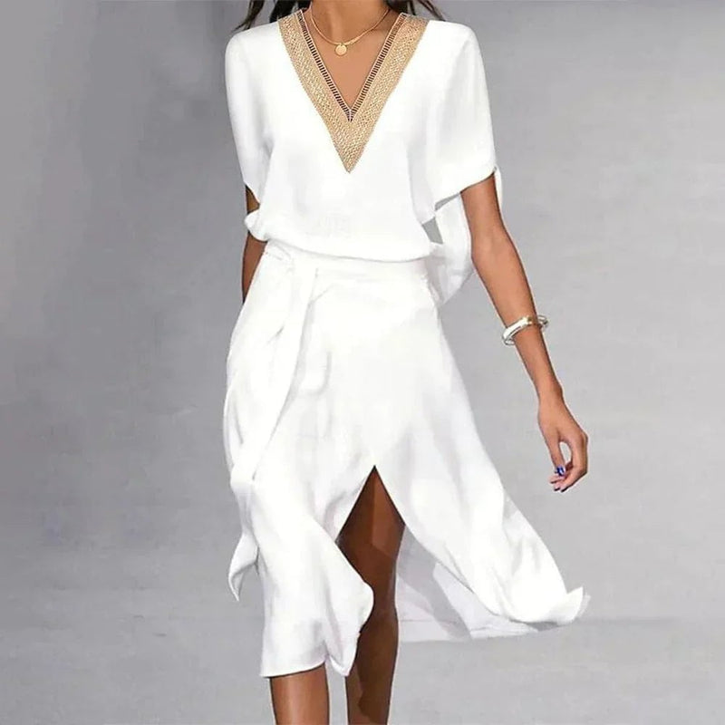 Side view of Florimay Lyra white midi dress showing flowing asymmetric hem and self-tie belted waist