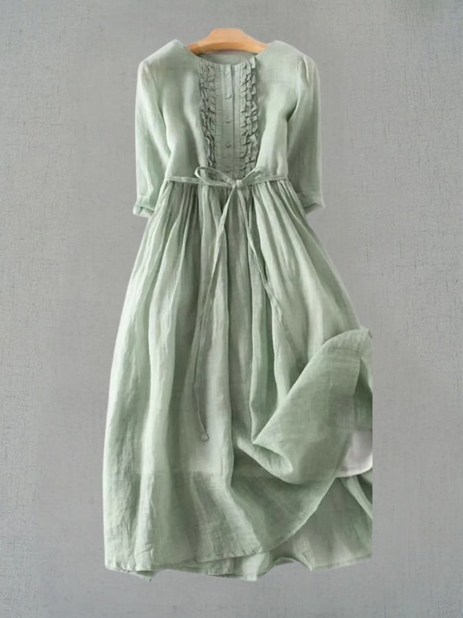 Woman wearing the Madeleine vintage-inspired dress in green, featuring a flattering waist-defining silhouette