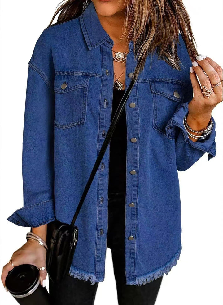 Side profile of woman in an oversized denim jacket layered over a simple outfit