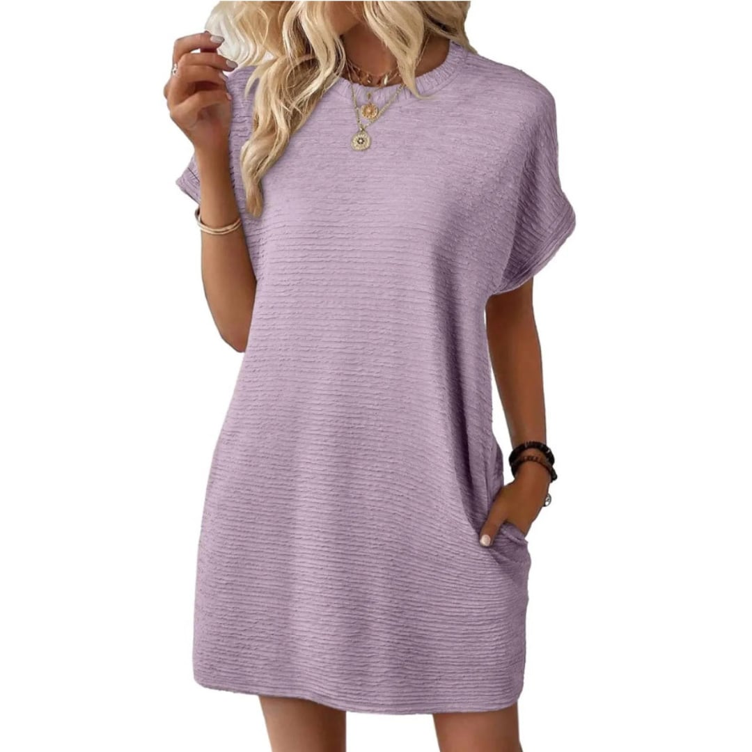 Woman wearing the Maggie short sleeve mini dress in Light Purple with gold hoop earrings