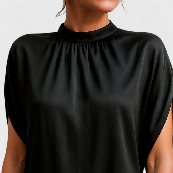 Full-length side view of a woman in a black mock neck mini dress highlighting the side slit hem and sleeve silhouette
