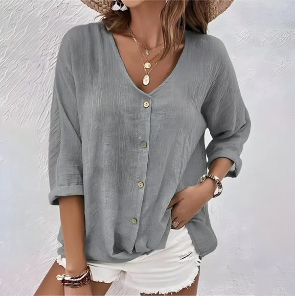 Close-up detail of the V-neckline and button front on a relaxed women's blouse