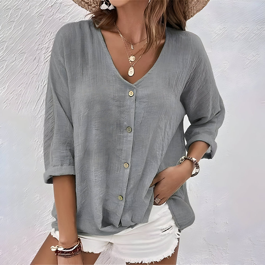 Side view of a women's relaxed fit button-up blouse showing roll sleeve detail