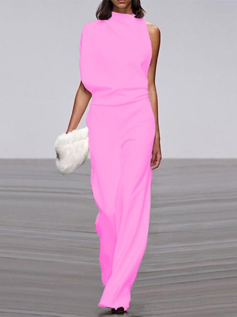 Close-up of the asymmetric one-shoulder neckline and gathered drape detail on a black wide-leg jumpsuit