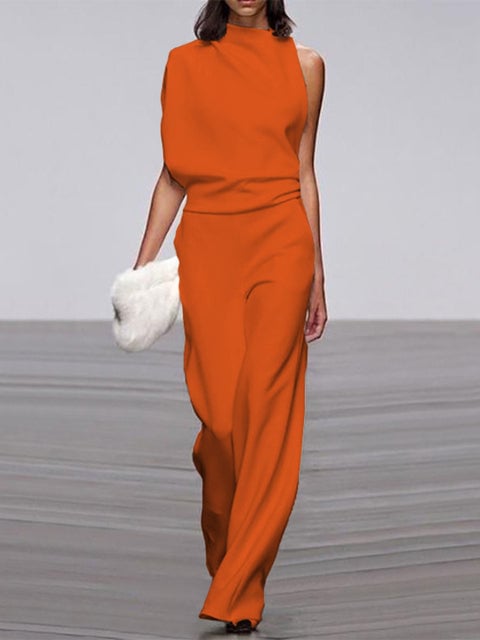 Woman in a pink one-shoulder wide-leg jumpsuit styled with strappy heels, full-length view