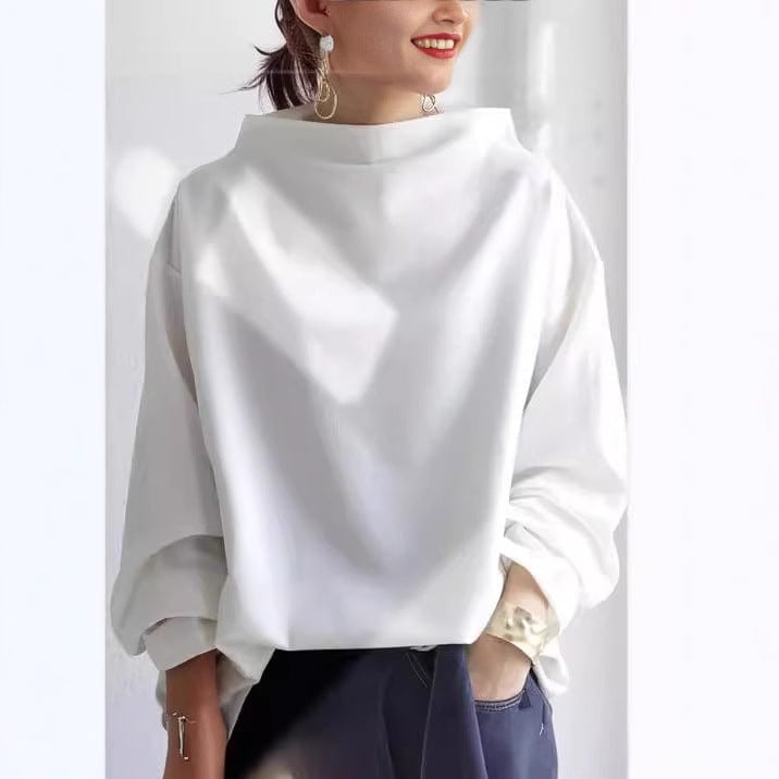 Model wearing the Margot high-neck knit top in blue styled with high-waisted pants