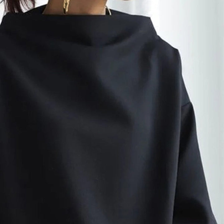 Flat lay of the Margot high-neck knit top in black highlighting the soft knit texture