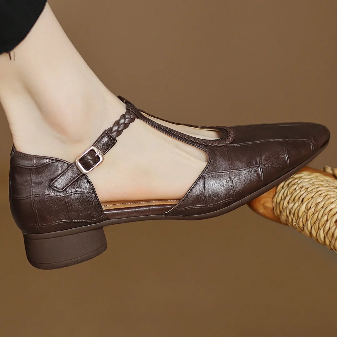 Close-up of braided T-strap and metal buckle detail on Margot mary jane flats in brown