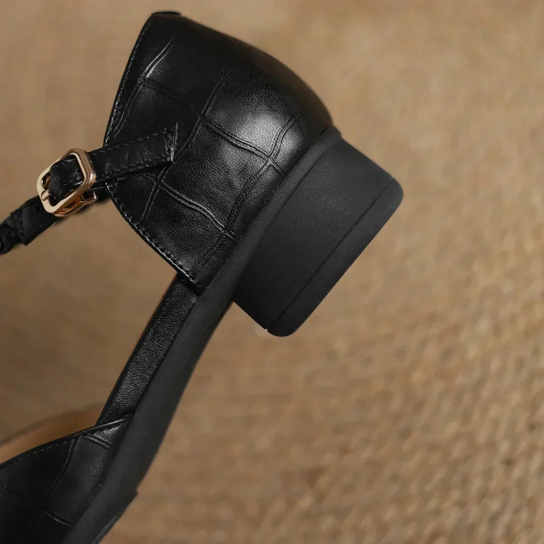 Margot leather mary jane flats in black worn on feet, styled with a midi skirt