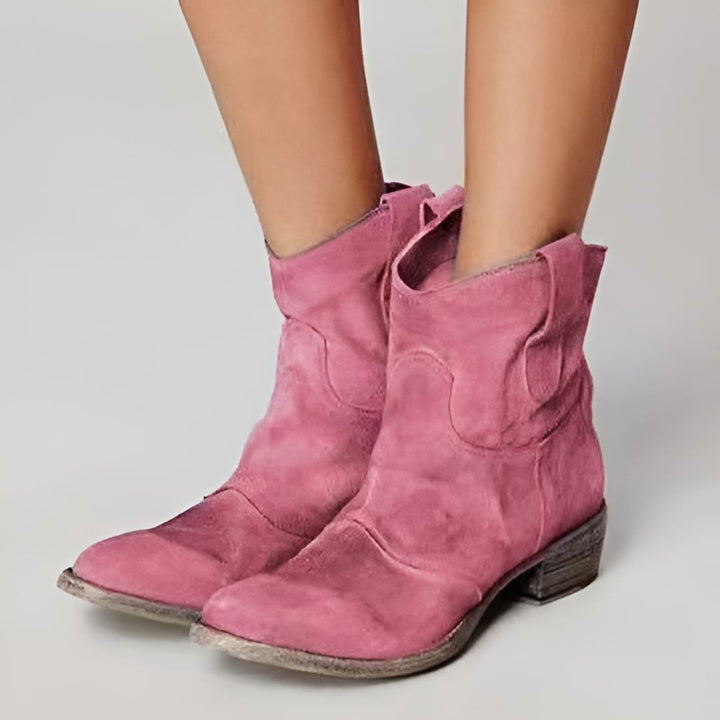 Women's suede ankle boots in brown worn with a midi skirt for an evening-ready outfit