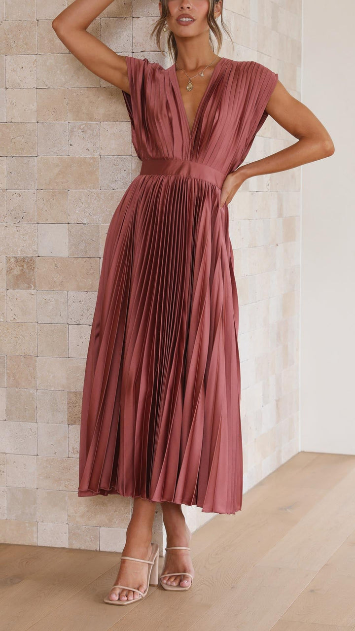 Model wearing an elegant pleated maxi dress in antique pink, full-length front view showing graceful pleated silhouette