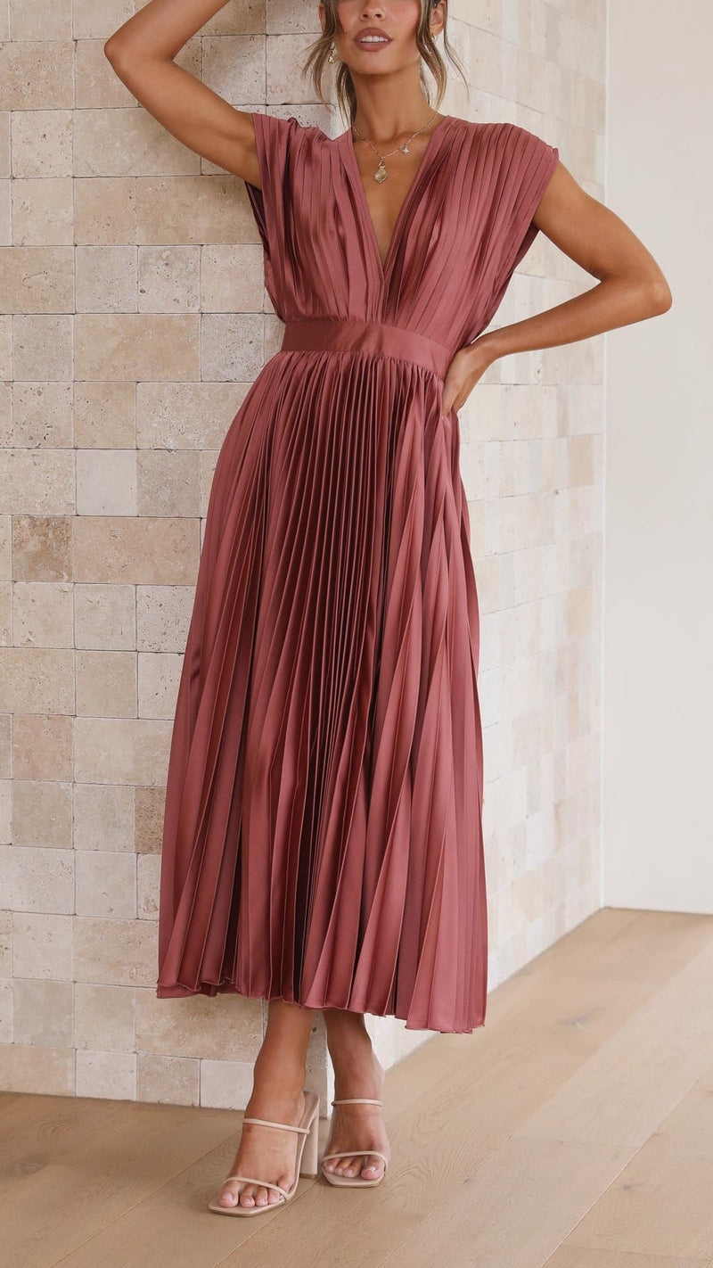 Model wearing an elegant pleated maxi dress in antique pink, full-length front view showing graceful pleated silhouette