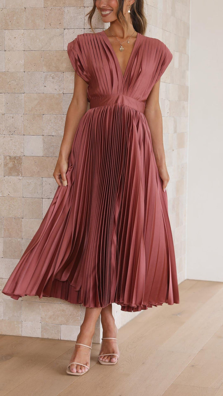 Close-up of antique pink pleated maxi dress highlighting soft fabric texture and flowing pleats