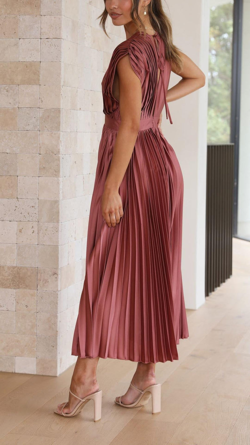 Side profile of model in antique pink pleated maxi dress showing high-waisted fit and floor-length hem
