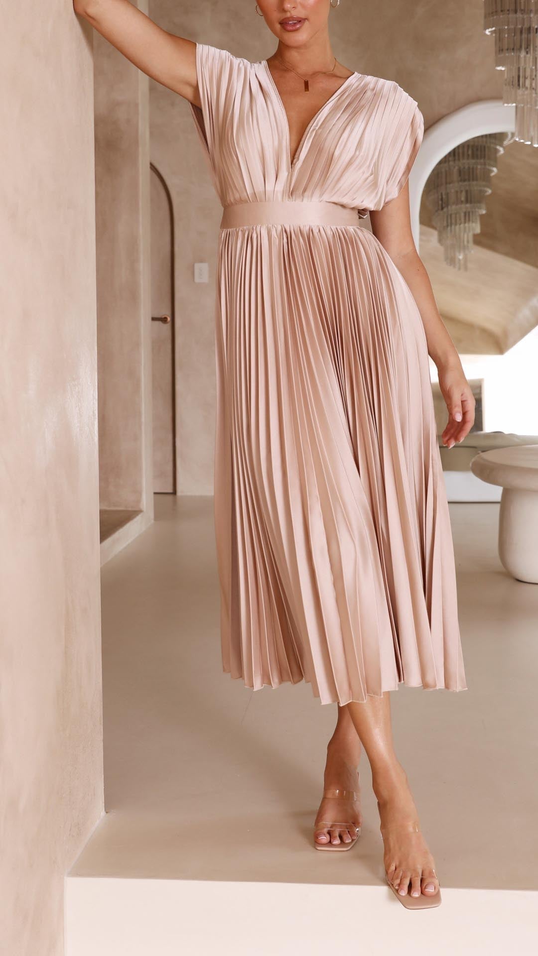 Side view of model in champagne pleated maxi dress showing dress movement and length