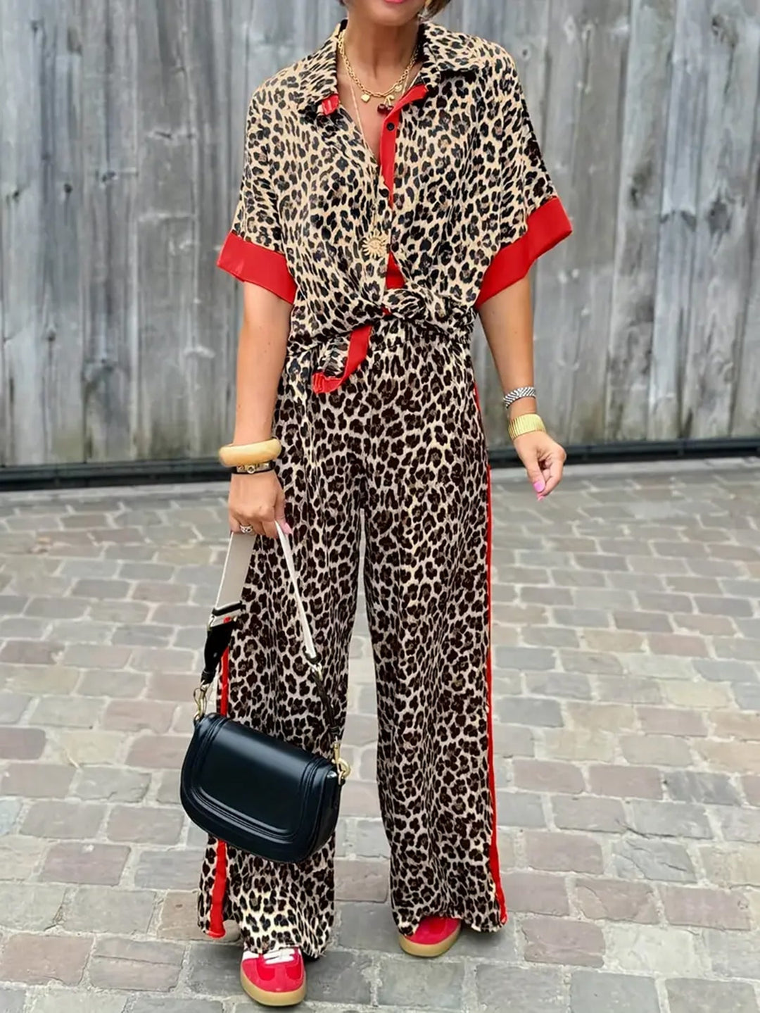 Model wearing a red fluid leopard print wide-leg two-piece set with elastic waistband and flowing pants
