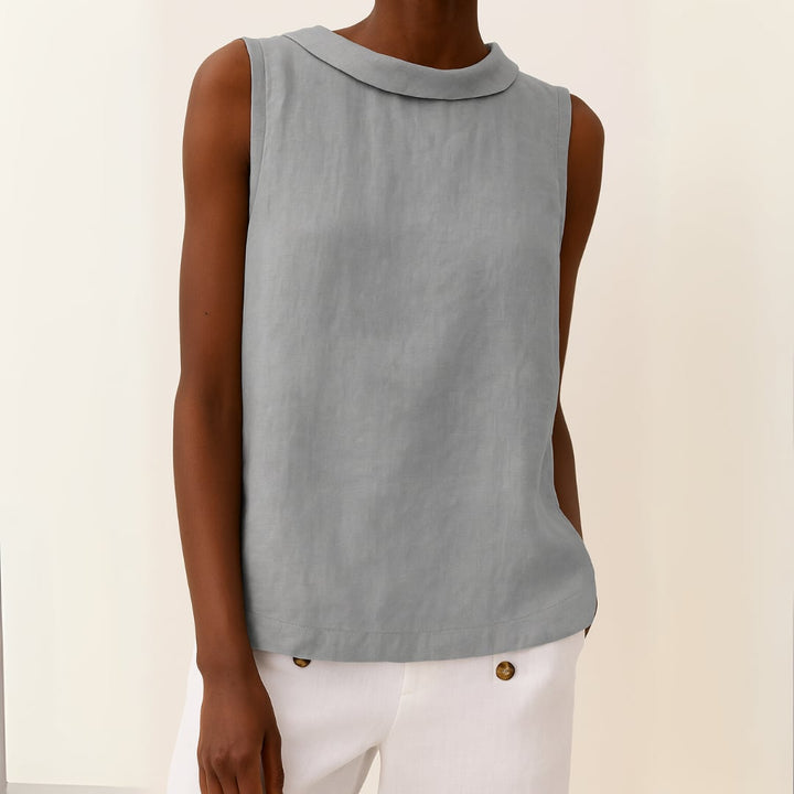 Woman wearing a sleeveless roll collar top in a neutral colorway, styled for a casual summer look