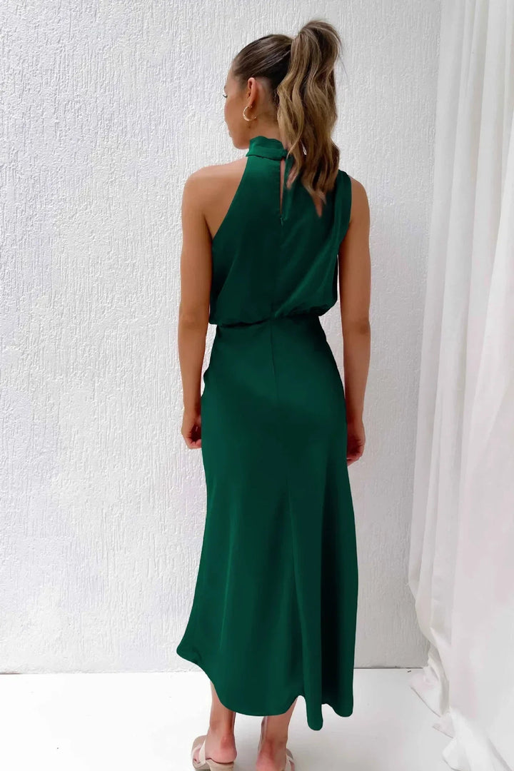 Model posing in a marine blue halter evening dress suitable for a wedding or gala event