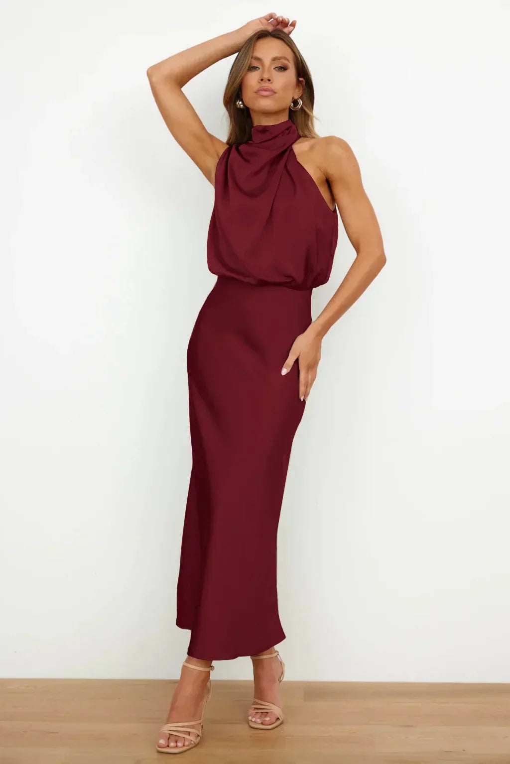 Model wearing the olive green halter evening dress paired with strappy heels