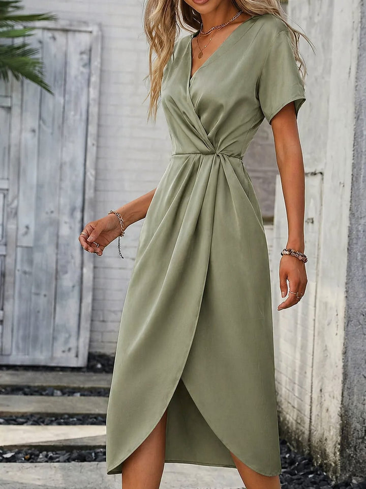 Detail shot of the green midi dress fabric and silhouette highlighting its elegant design