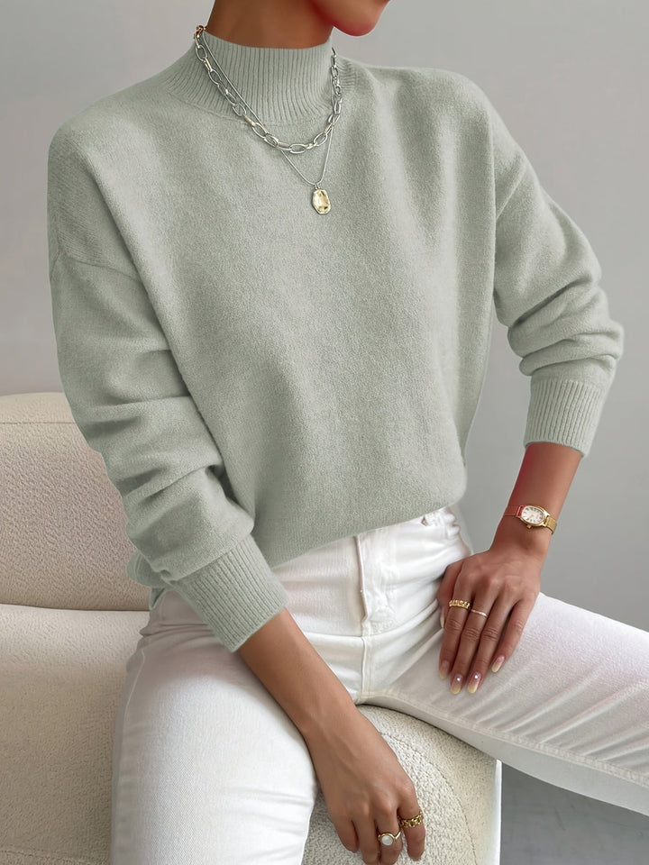 Woman wearing an elegant turtleneck sweater in a soft neutral color, styled for a polished everyday look