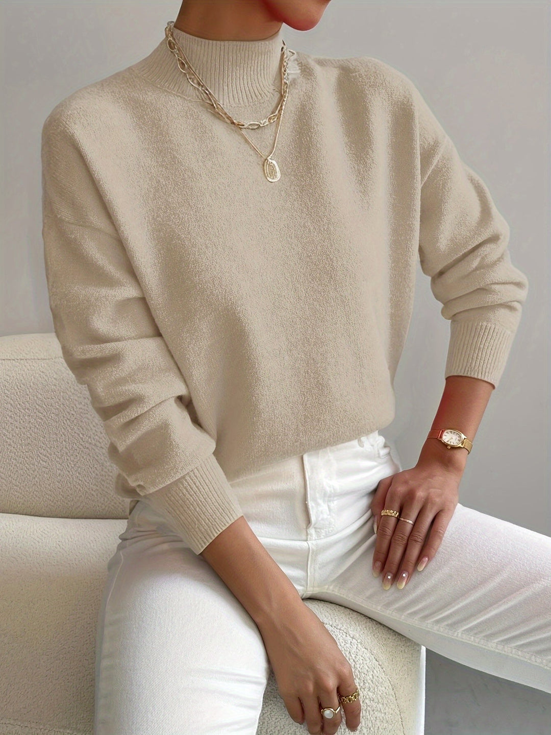 Woman wearing a white turtleneck sweater with a relaxed yet refined casual style