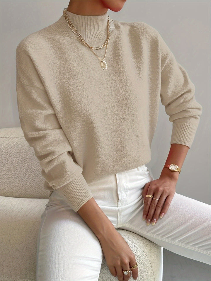 Woman wearing a white turtleneck sweater with a relaxed yet refined casual style