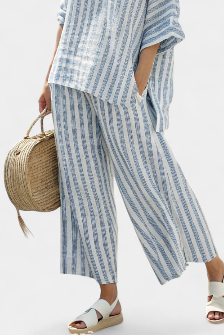 Close-up of the Marina striped set showing the round neckline, chest pocket detail, and vertical blue stripe print