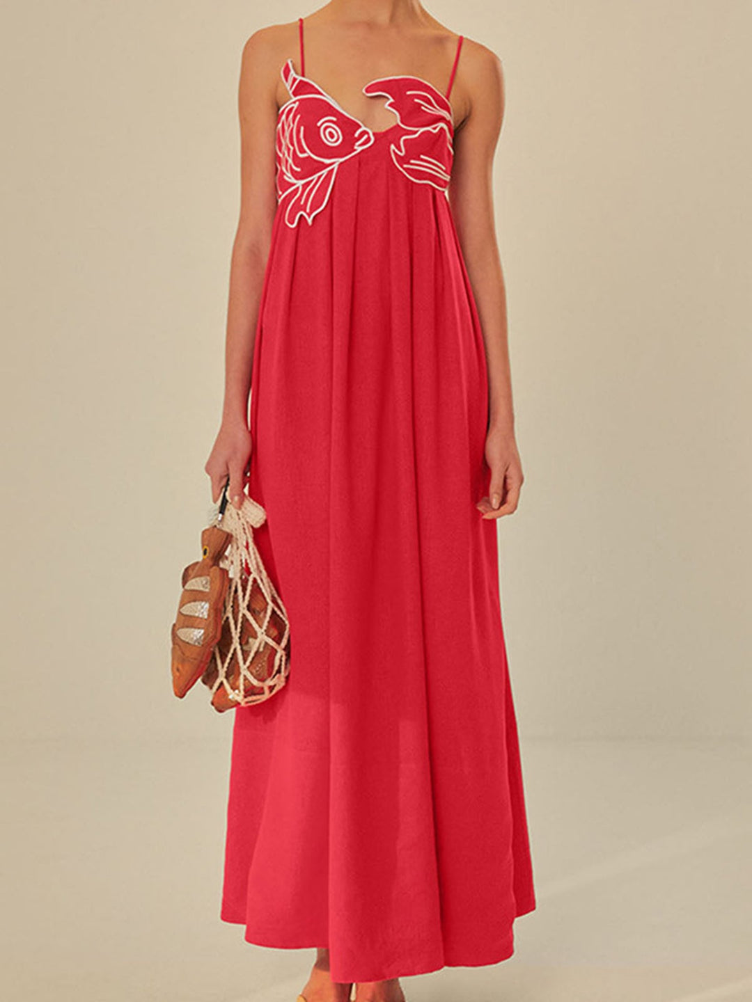 Woman wearing a red embroidered spaghetti strap maxi shift dress in a relaxed summer setting, front view