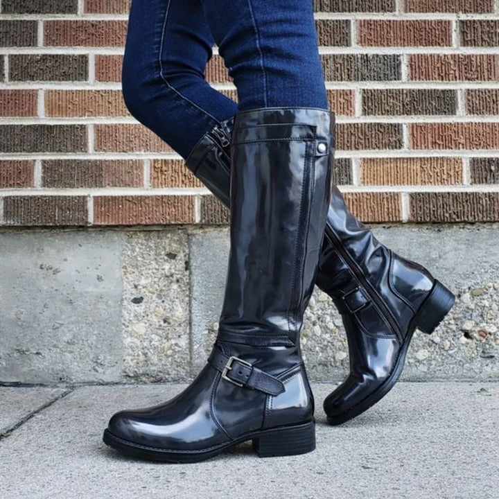 Side profile view of classic knee-high boots with a supportive sole and smooth upper