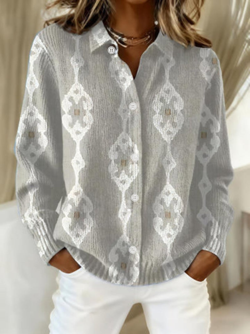 Woman wearing the Maura elegant blouse in light gray, featuring a polished silhouette and soft draping fabric