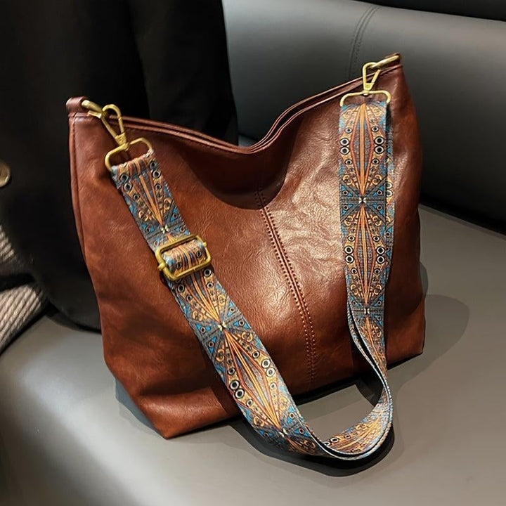 Brown classy fashion bag with elegant patterned strap, front view