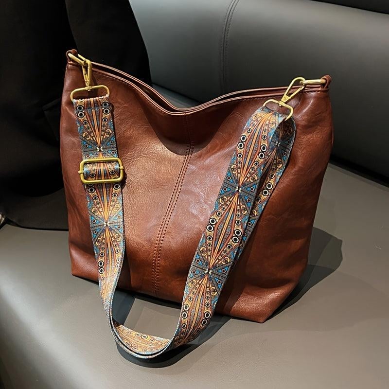 Black classy fashion bag with patterned strap detail, front view